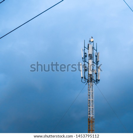 Technology of telecommunication GSM (5G,4G,3G) tower. Cellular phone antennas on a building roof. Receiving and transmitting stations with blue skies on the background.