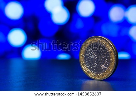 Bimetal euro coin close-up on a background of blue bokeh. View with space for your text.