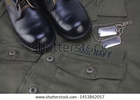 U.S. Navy Branch Tape with dog tags on olive green uniform background