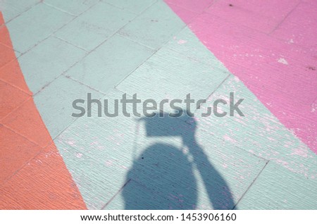 Shadow of a photographer with camera on colourful pavement
