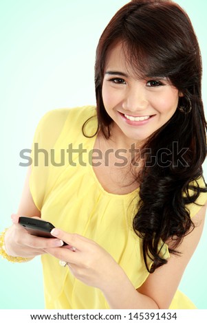 Portrait of a smiling beautiful woman texting with her phone