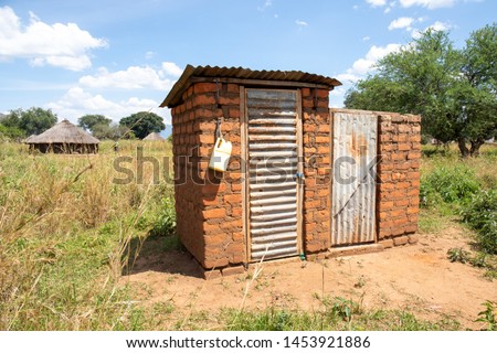 Outdoor latrine in rural uganda with hand washing station Royalty-Free Stock Photo #1453921886