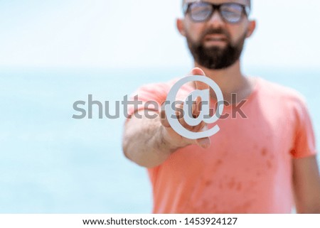 Happy Man Holding Email Sign Over Sea Background. Concept for email, communication or contact us