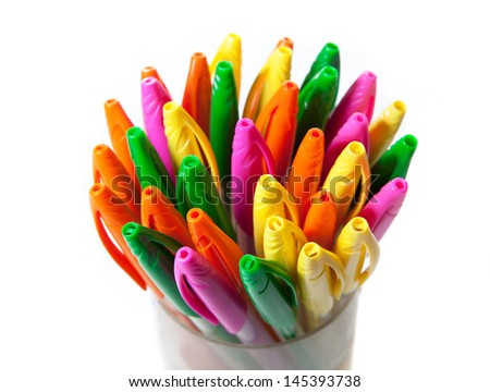 many colorful pens in a plastic glass, isolated on white