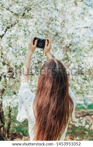 Young charming girl taking pictures on old retro camera