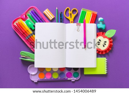Stationery flat lay. Bright material for a child Back to school. Violet background kid child. Around office supplies are the color of the rainbow.