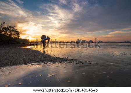 Photographer with backpack enjoying sunshine. Landscape of paradise tropical island, sunrise shot