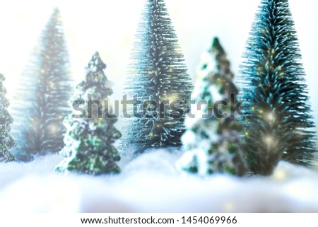 Mini snowy Christmas trees in the forest. Bokeh lights background.close up.
