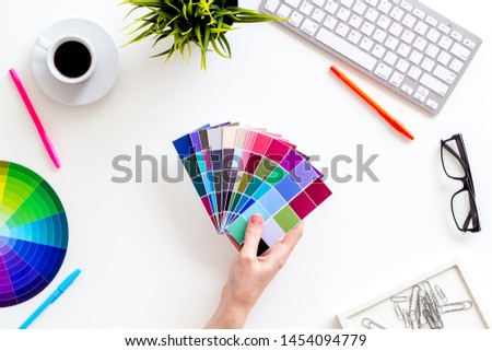 Designer work space with pallet in hands, glasses, keyboard and coffee on white background top view