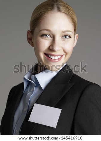Closeup portrait of a cheerful young businesswoman against gray background