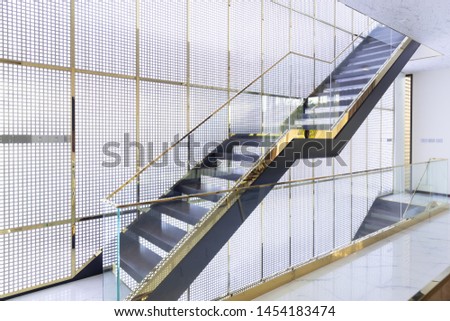 architecture of luxury wooden staircase with glass railing and gold handrail in golden grille house interior. Royalty-Free Stock Photo #1454183474