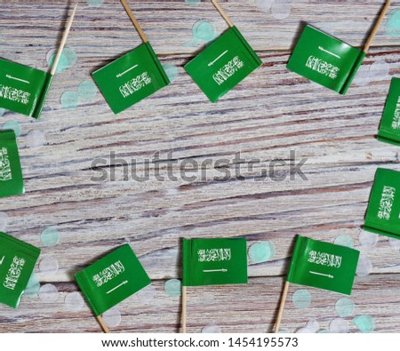 23 September, al-Yaom al-Watani, Day of proclamation of the Kingdom of Saudi Arabia. happy independence day concept of patriotism. mini flags with colorful confetti on wooden background