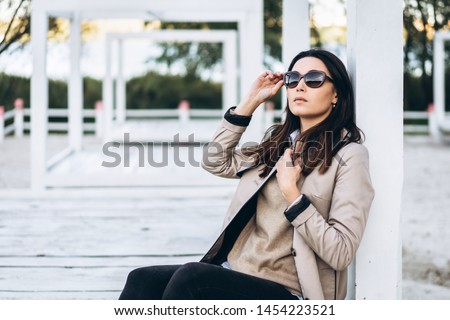 Pretty long hair brunette girl in sunglasses relaxing outdoor