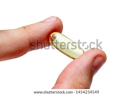 Vitamin e omega 3 fish oil yellow pills in a hand vitamins sport nutrition healthy on the white background isolated close up