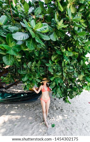 girl on the beach against a tropical tree. Thailand