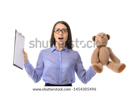 Troubled young businesswoman with toy and clipboard on white background