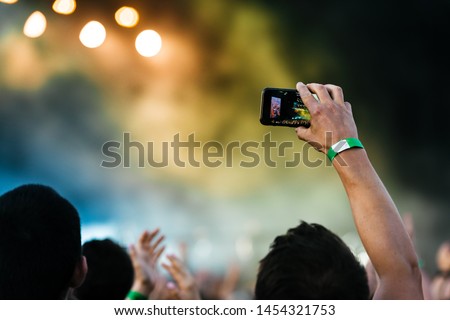 Close up of recording video with smartphone during a concert.
