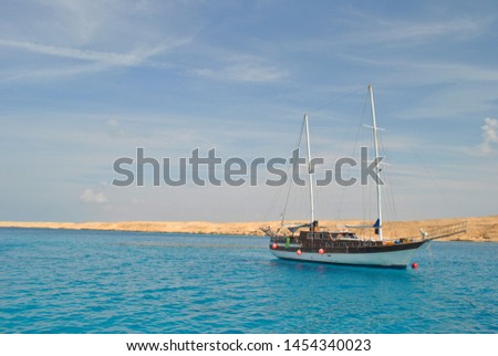 Ship against the blue sea and golden sand.  Ship in the open red Sea. Egy.  Royalty-Free Stock Photo #1454340023