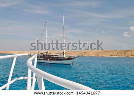 Ship against the blue sea and golden sand.  Ship in the open red sea Royalty-Free Stock Photo #1454341697