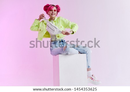 woman with pink hair in stylish clothes is sitting