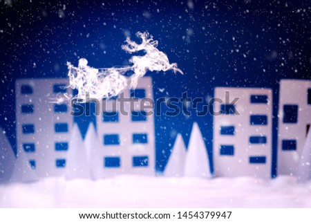 Steam in reindeer and Santa Claus into sled shape flying over paper houses in snowy landscape. Christmas or New Year celebration concept. Copy space