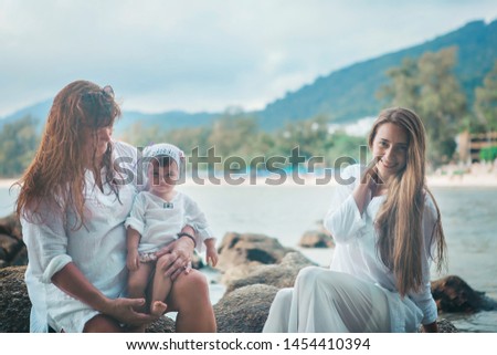 family holiday by the sea: man, woman and child on the beach. concept of travel