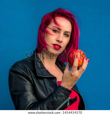 girl with red or crimson hair on blue wall background 