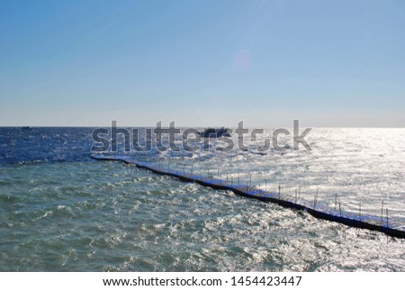 The bridge on the water, the sea of ​​turquoise and blue, yacht in the distance, sunny windy day Royalty-Free Stock Photo #1454423447