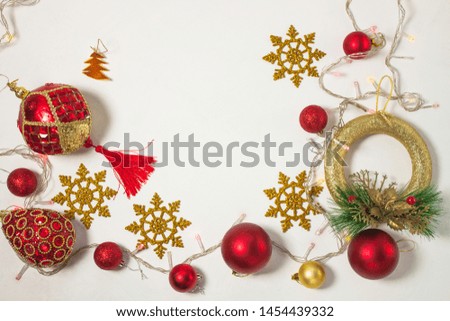 Christmas present box with red ribbon, gold decorations, balls, wreath, snowflakes and lights on a white background. New year concept, holidays composition, winter flatlay. Top view. Copy space.