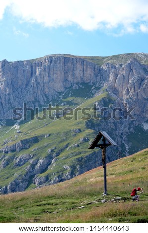 Wooden crucifix in a meadow mountain
