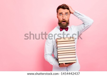 Photo portrait of clever guy holding stack of paper book in hand touching head isolated pastel background