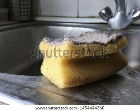 Very dirty sponge and a sink in a bad condition Royalty-Free Stock Photo #1454444360