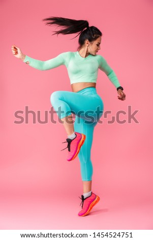 Picture of amazing concentrated young sports fitness woman isolated over pink wall background make exercises.