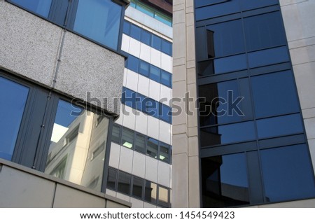 windows and reflections in the windows of a group of large modern office buildings in a city business district