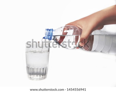 Close-up pouring purified fresh drink water from the bottle isolated on white background