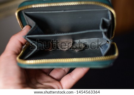 Close up of empty wallet with some coins in it. Royalty-Free Stock Photo #1454563364