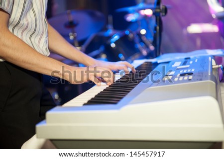 man playing electronic piano at concert