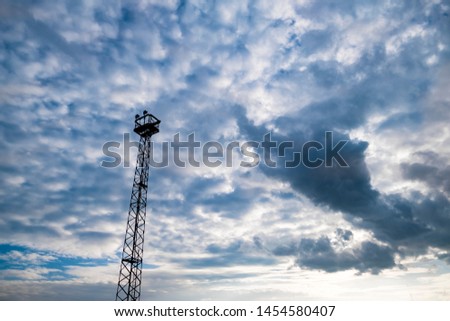 Outstanding outpost of the lighthouse tower in the evening pastel blue cloudy sky