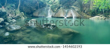 Erawan Waterfall is recognized as one of the most beautiful waterfalls in Thailand has seven separate tiers. cascade in tropical rainforest with rock and turquoise blue pond at Erawan National Park