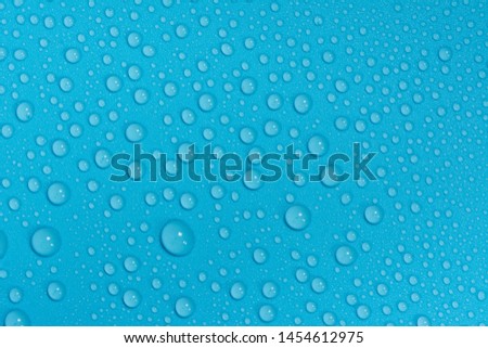 Close up of water drops on blue sky tone background. Abstract blue wet texture with bubbles on plastic PVC surface or grunge. Realistic pure water droplets condensed. Detail of canvas leather texture