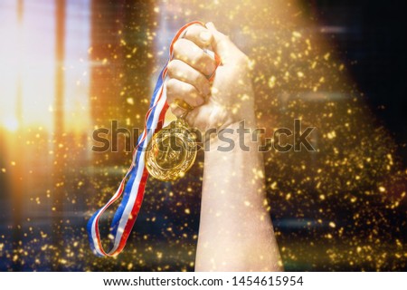 Gold medal with  ribbon  in hand on  background