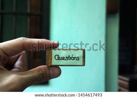 Writing Note - The words Questions on brown wood plank with blurred background - Communication with the deaf at Cafe