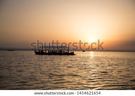 People in a boat staring at the sunset over a lake in the Natural Park of La Albufera. Valencia, Spain