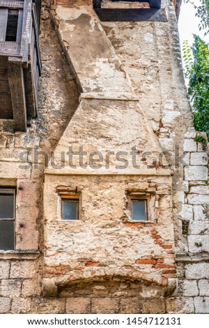 The original fake fireplace on the wall of a house. Decorative pattern. Decoration of a stone wall with Windows in the form of a fireplace