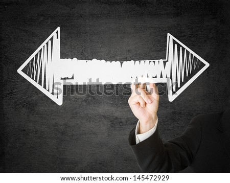 Businessman with pen drawing arrows pointing left and right - decision or strategy concept