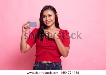 Young Asian woman point to a blank card on pink background