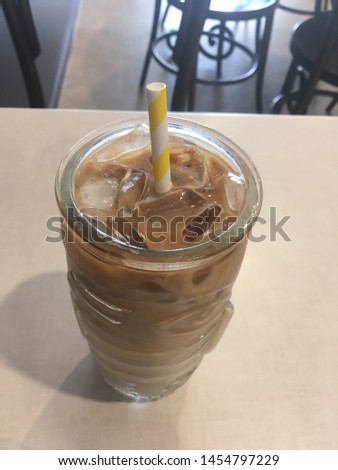 Iced Coffee in a coffeeshop. Cold Bewerage. Paper straw.