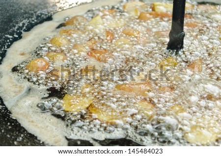 Potatoes frying in cauldron