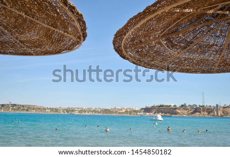 Wicker homemade canopies, against the blue sky and the sea Royalty-Free Stock Photo #1454850182