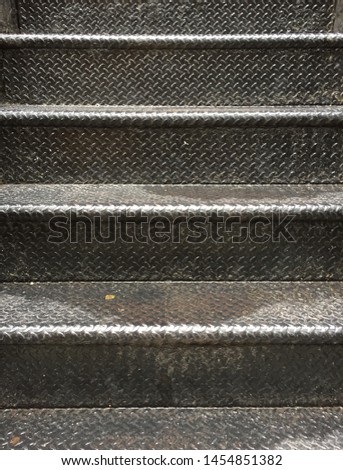 Patterned black metal staircase after the rain
